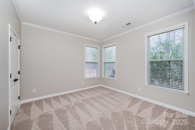 carpeted spare room with visible vents, baseboards, and ornamental molding