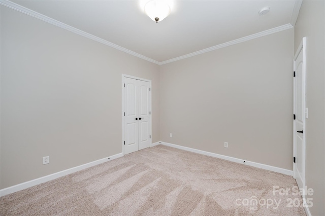 carpeted spare room with crown molding and baseboards