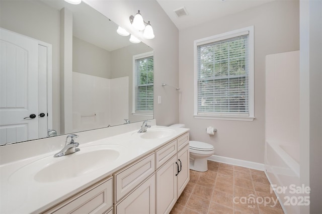 bathroom featuring a sink, visible vents, baseboards, and double vanity