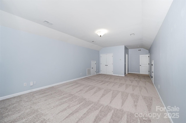 bonus room featuring visible vents, light colored carpet, baseboards, and vaulted ceiling