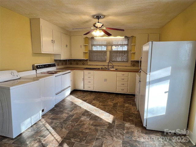 kitchen with white appliances, a ceiling fan, open shelves, washer / dryer, and a sink