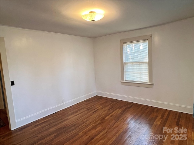 unfurnished room featuring dark wood-style floors and baseboards