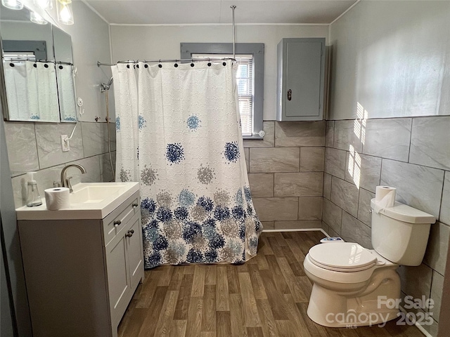 full bathroom with tile walls, toilet, wood finished floors, and ornamental molding