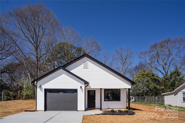 view of front of home with concrete driveway and fence