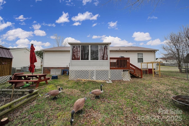 rear view of house with a wooden deck, fence, and a sunroom