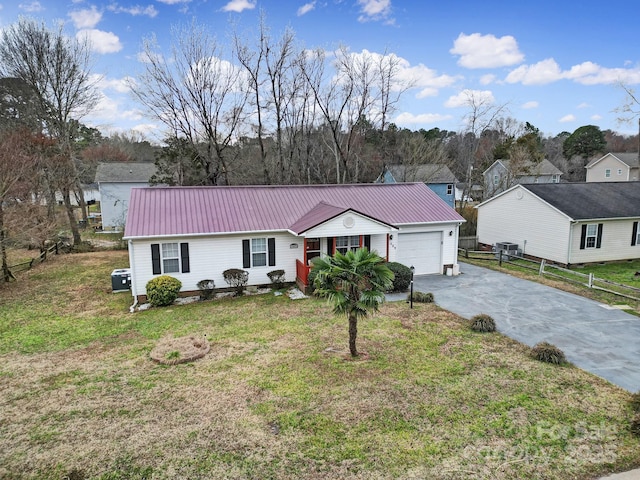 ranch-style home with metal roof, driveway, an attached garage, and a front yard