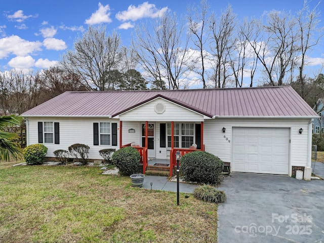 ranch-style house with covered porch, an attached garage, metal roof, and a front lawn