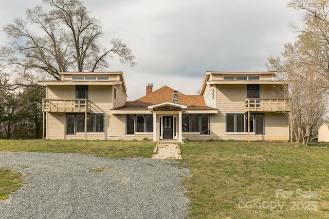 3607 Austin Rd, Monroe, NC 28112 - view of front of home featuring a balcony, a chimney, and a front lawn