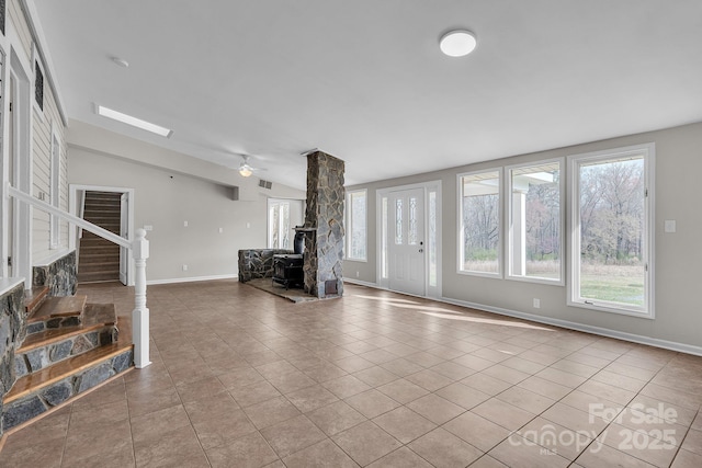 3607 Austin Rd, Monroe, NC 28112 - unfurnished living room with tile patterned flooring, baseboards, stairway, lofted ceiling, and a wood stove