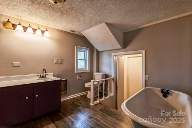 3607 Austin Rd, Monroe, NC 28112 - bathroom with visible vents, toilet, a textured ceiling, wood finished floors, and a freestanding bath