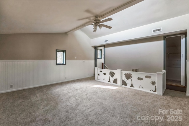 3607 Austin Rd, Monroe, NC 28112 - carpeted spare room with lofted ceiling with beams, a ceiling fan, a wainscoted wall, and visible vents