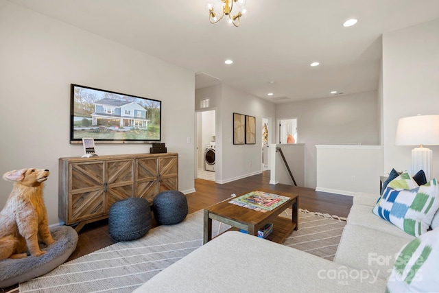 living room featuring baseboards, recessed lighting, washer / dryer, wood finished floors, and a notable chandelier