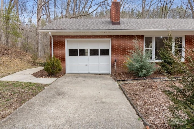 view of front facade with concrete driveway, an attached garage, brick siding, and a chimney