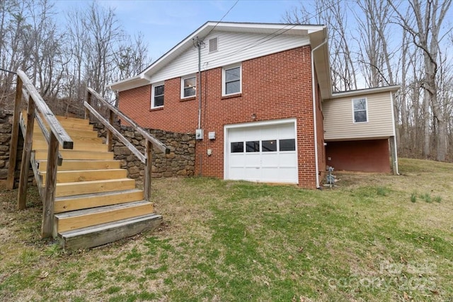 back of property featuring stairs, a garage, a lawn, and brick siding