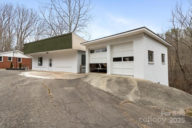 view of front of property featuring aphalt driveway and a garage