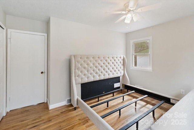 bedroom featuring visible vents, baseboards, and wood finished floors