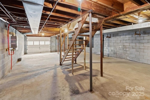 unfinished basement with stairs, electric panel, and visible vents