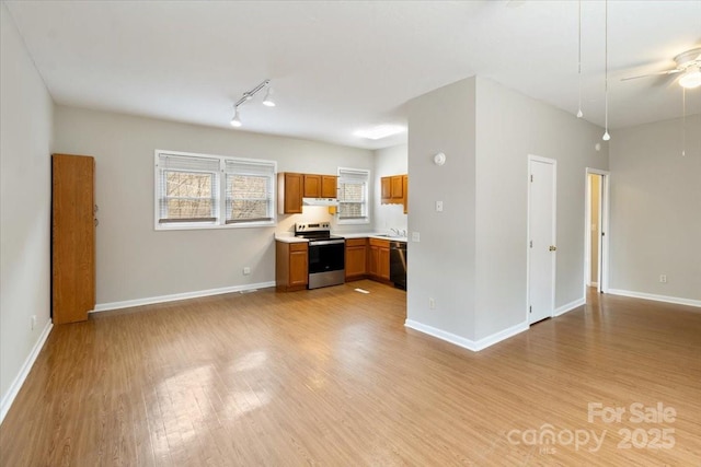 kitchen featuring stainless steel electric range oven, black dishwasher, open floor plan, and light wood finished floors