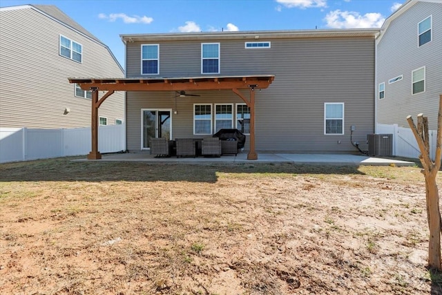 rear view of house with central AC unit, a fenced backyard, a yard, a patio area, and a ceiling fan