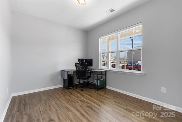 office space with visible vents, baseboards, and wood finished floors