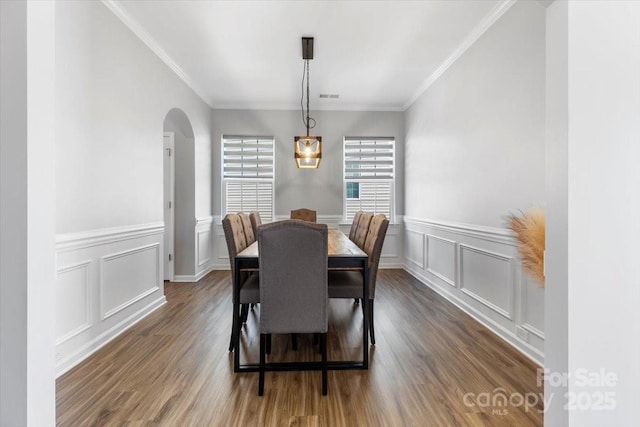 dining space with visible vents, arched walkways, dark wood-type flooring, and crown molding