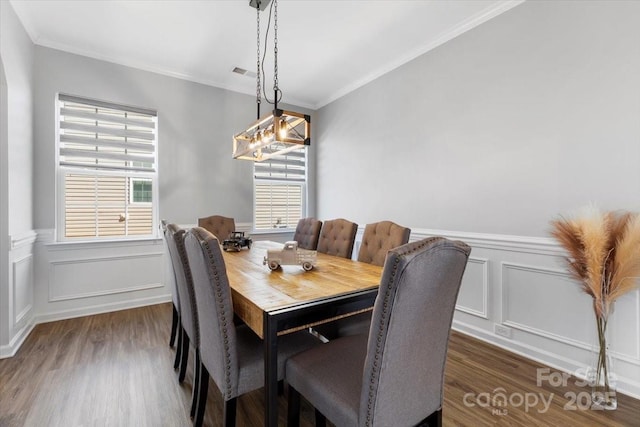 dining area featuring visible vents, wood finished floors, and ornamental molding