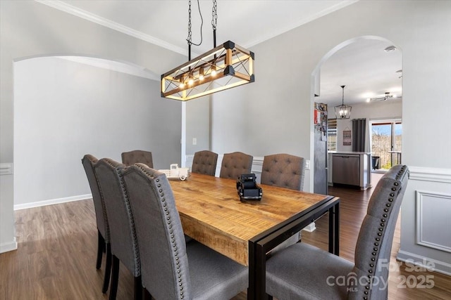 dining room featuring arched walkways, dark wood-type flooring, and ornamental molding