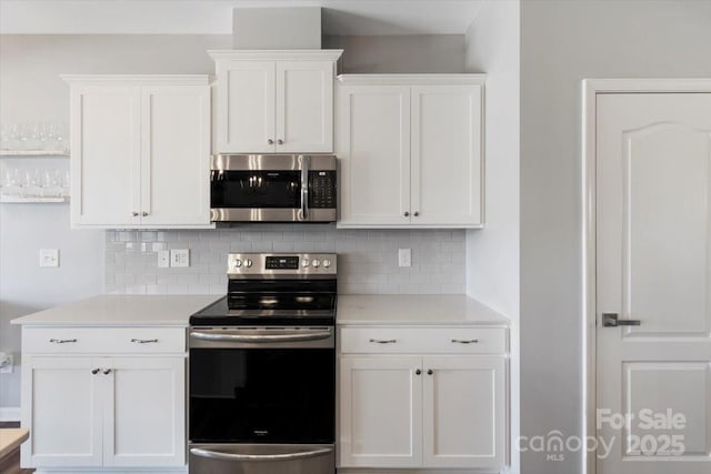 kitchen featuring decorative backsplash, appliances with stainless steel finishes, white cabinetry, and light countertops