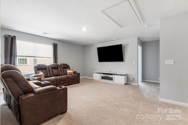 living area with visible vents, baseboards, light colored carpet, and attic access