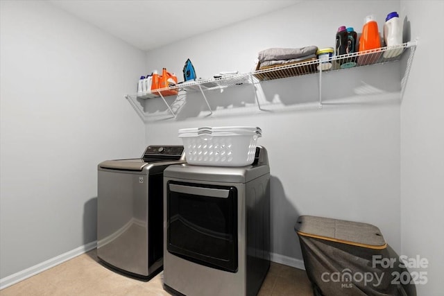 washroom featuring light tile patterned floors, baseboards, independent washer and dryer, and laundry area