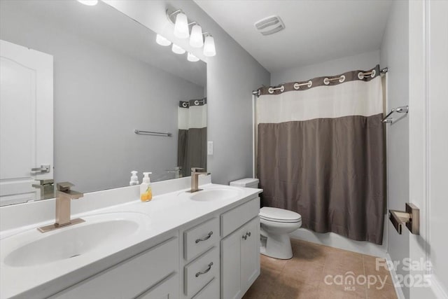 bathroom with double vanity, toilet, visible vents, and a sink