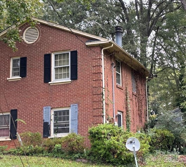 view of side of home with brick siding