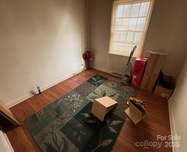 empty room featuring visible vents, baseboards, and wood finished floors