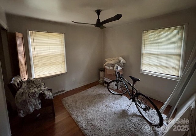 miscellaneous room with ceiling fan, visible vents, baseboards, and wood finished floors