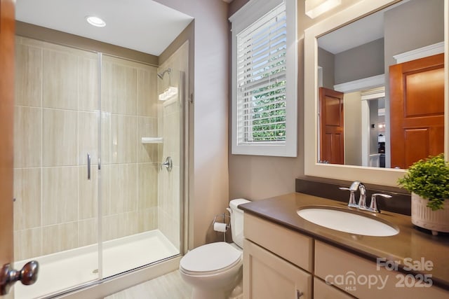 bathroom with vanity, toilet, and a shower stall