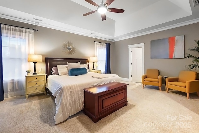 bedroom featuring visible vents, ceiling fan, ornamental molding, a raised ceiling, and light colored carpet