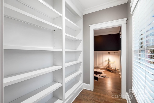 corridor featuring wood finished floors and crown molding