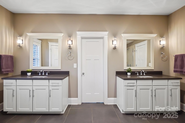 full bath featuring a sink, two vanities, and tile patterned floors