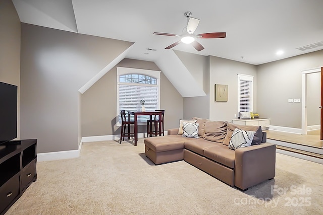 living room featuring baseboards, a ceiling fan, visible vents, and light carpet