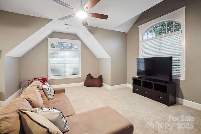 carpeted living area with visible vents, baseboards, lofted ceiling, and ceiling fan