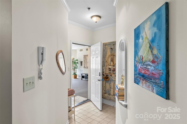 corridor with light tile patterned flooring and crown molding