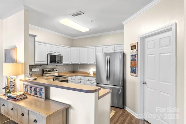 kitchen with stainless steel appliances, visible vents, a peninsula, and white cabinets