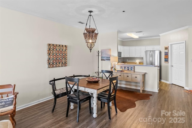 dining room with baseboards, an inviting chandelier, dark wood finished floors, and crown molding