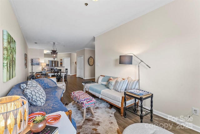 living area featuring crown molding, baseboards, and wood finished floors