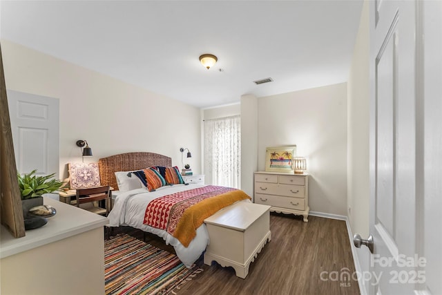 bedroom with dark wood-style floors, visible vents, and baseboards