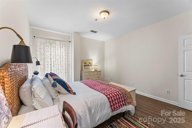 bedroom featuring visible vents, baseboards, and wood finished floors