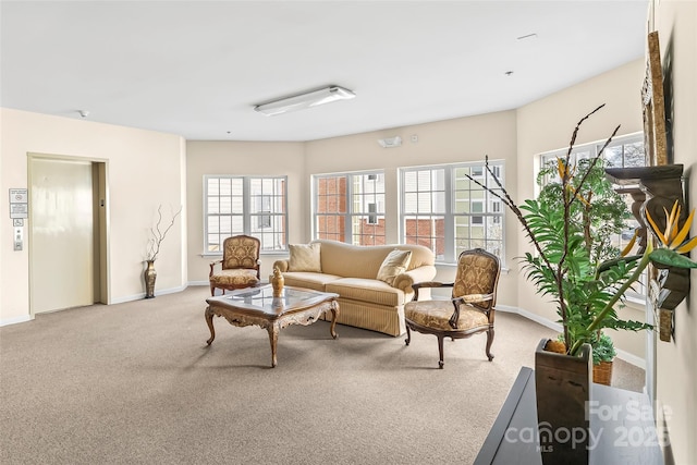 living room with elevator, baseboards, and carpet floors