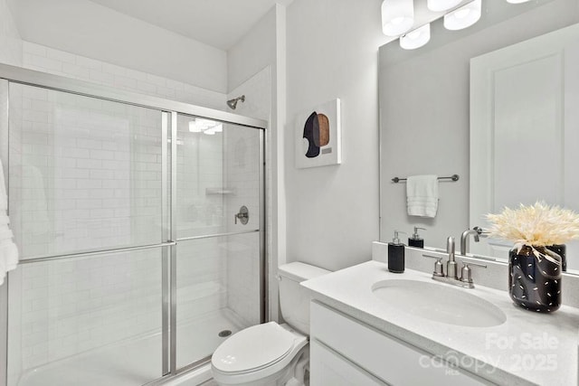 full bath featuring vanity, a shower stall, and toilet