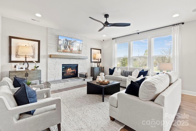 living room featuring recessed lighting, baseboards, wood finished floors, and a fireplace