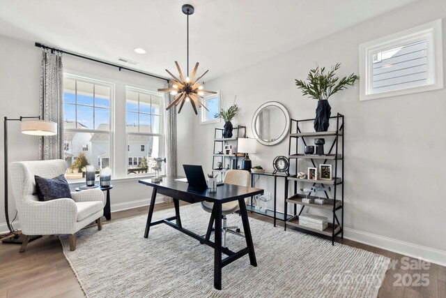 office featuring visible vents, an inviting chandelier, baseboards, and wood finished floors